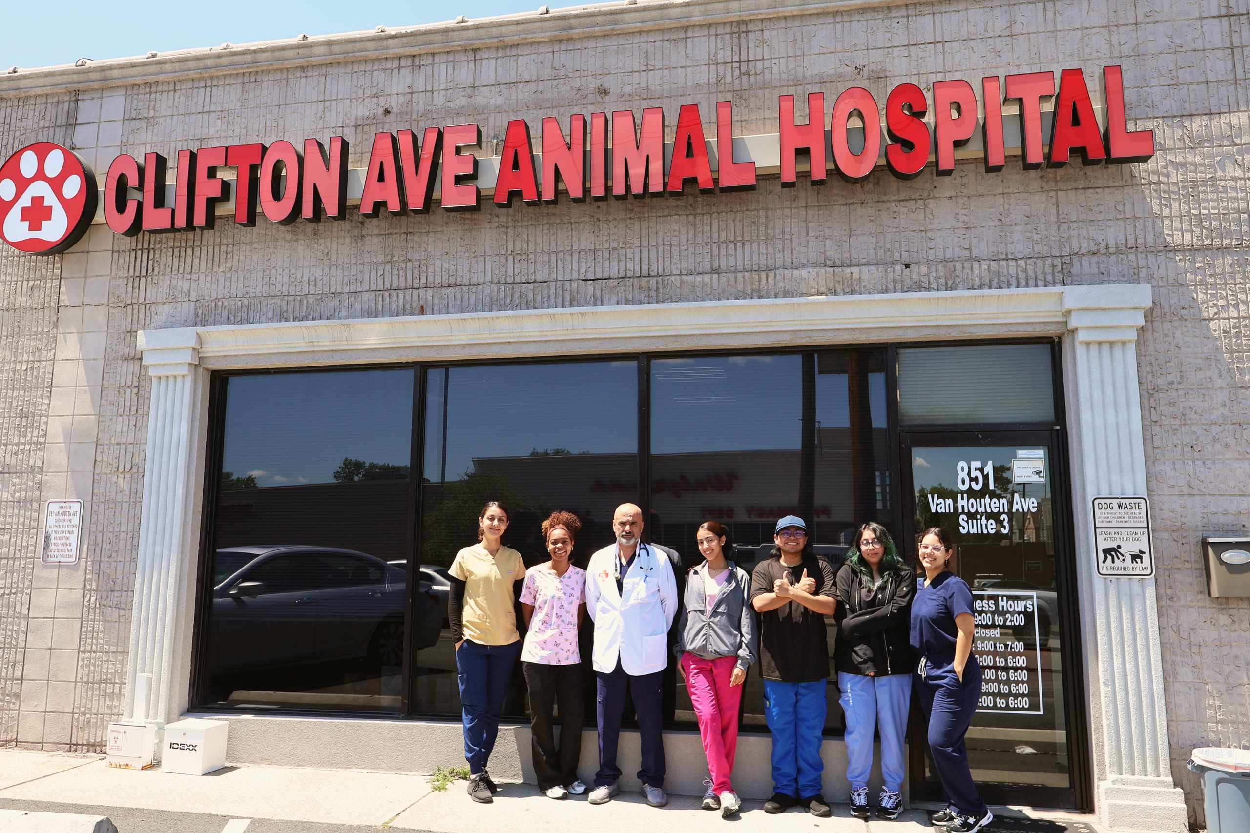 The Clifton Ave Animal Hospital team outside the hospital entrance at 851 Van Houten Ave